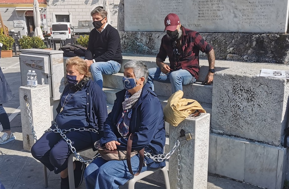 Commercianti e ristoratori si incatenano al monumento dei Caduti a Sarzana